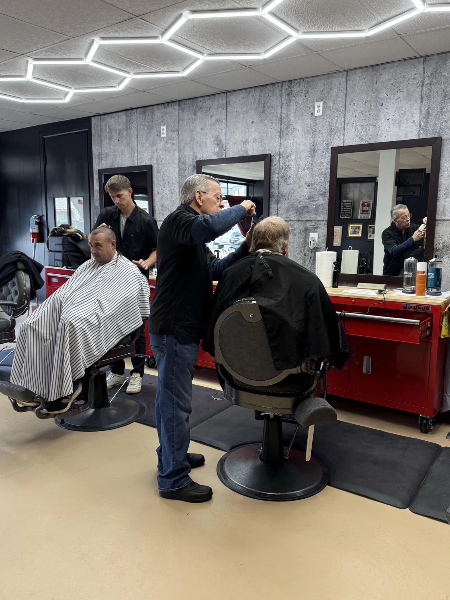 Barbers at work inside Fade The Grain Barbershop
